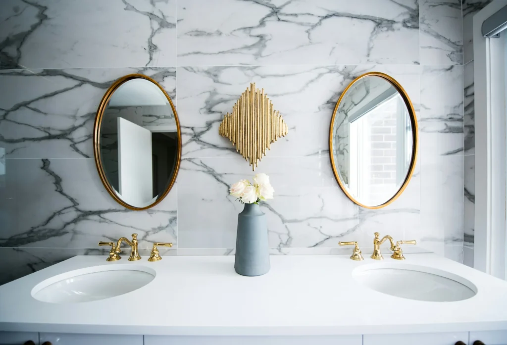 Piano lavabo in marmo lucido con rubinetteria dorata